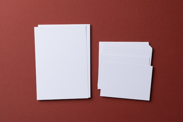 Blank white business cards on burgundy paper background