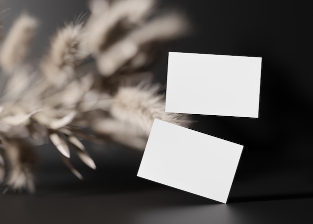 Фото Пустые белые визитные карточки на черном фоне с сушеными растениями макет для фирменного стиля две карточки для демонстрации обеих сторон шаблон для графических дизайнеров бесплатное пространство для копирования 3d-рендеринг