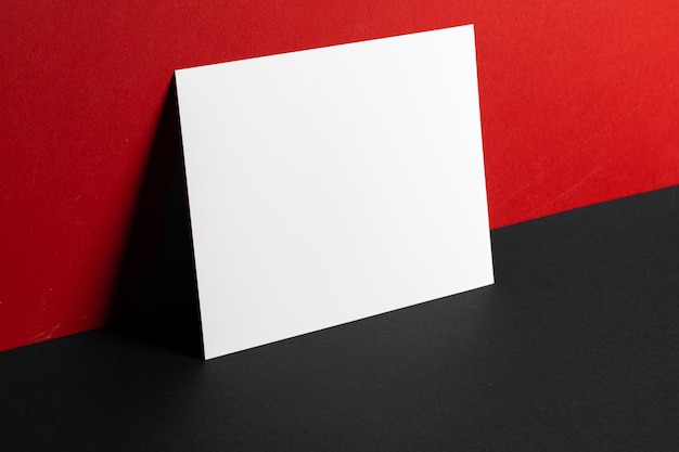 Blank white business cards on red and black paper background, copy space