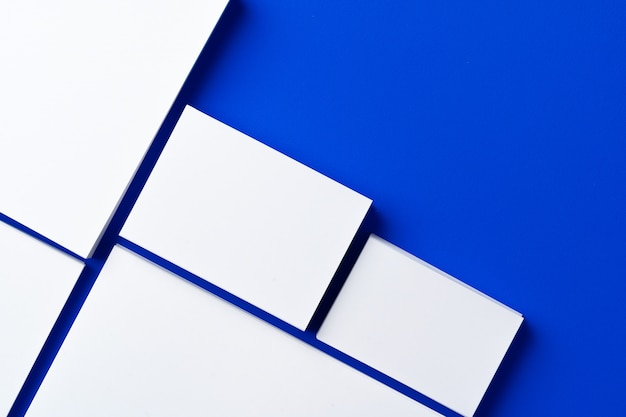 Blank white businesscards on classic blue background