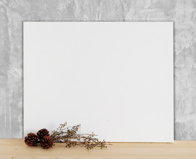 Photo blank white canvas frame on wood floor and cement wall background