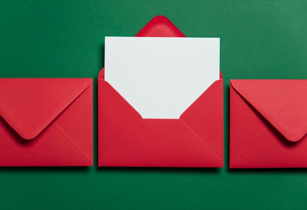赤い紙の封筒と空白の白いカードクリスマスカードテンプレートのモックアップ