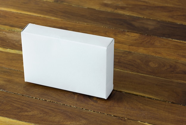 Blank white cardboard package box on dark wooden table