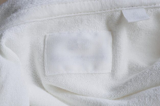 Blank white clothes label on new cotton shirt background