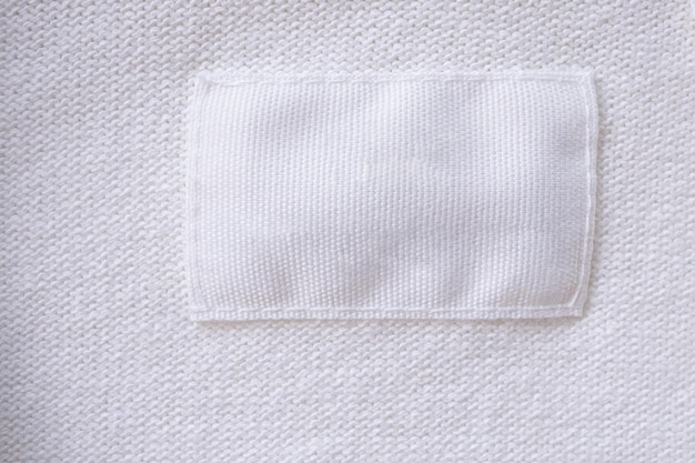 Blank white clothes label on new shirt background