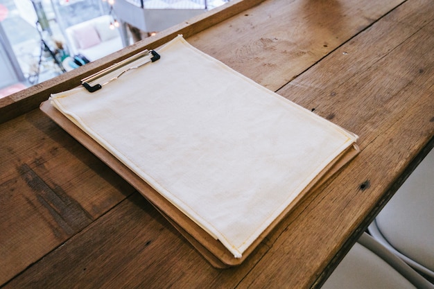 Blank white fabric on paper board place on wooden top table. 