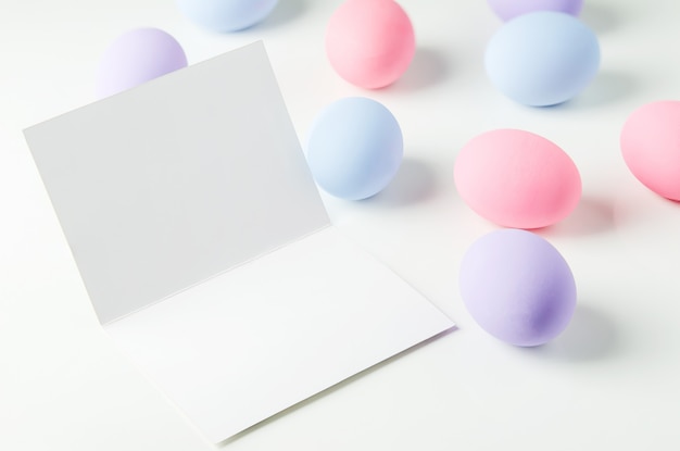 Foto cartolina d'auguri bianca in bianco con le uova di pasqua pastelli