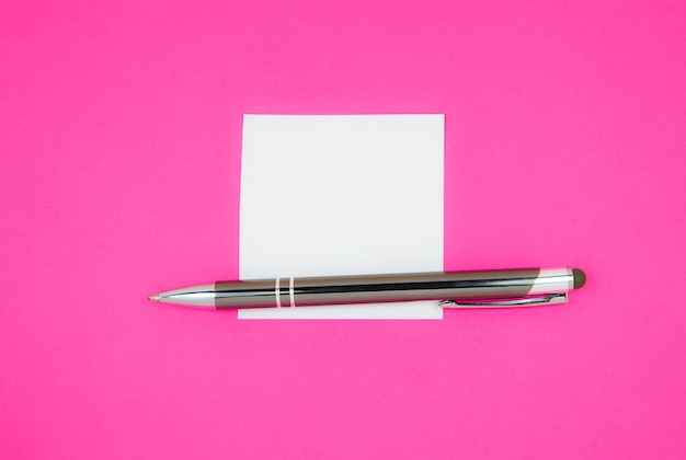 Blank white to do list sticker with pen searching information\
on the internetxaclose up of reminder note paper on the pink\
background copy space minimalism original and creative