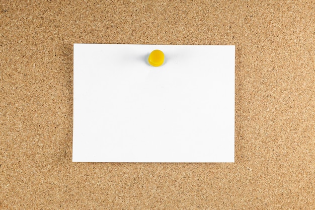 blank white note papers is pinned to a cork board.