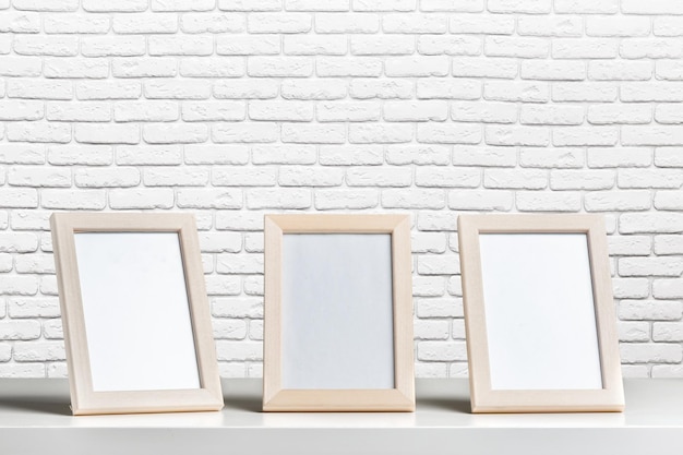 Photo blank white picture frame on the wall and the table wood