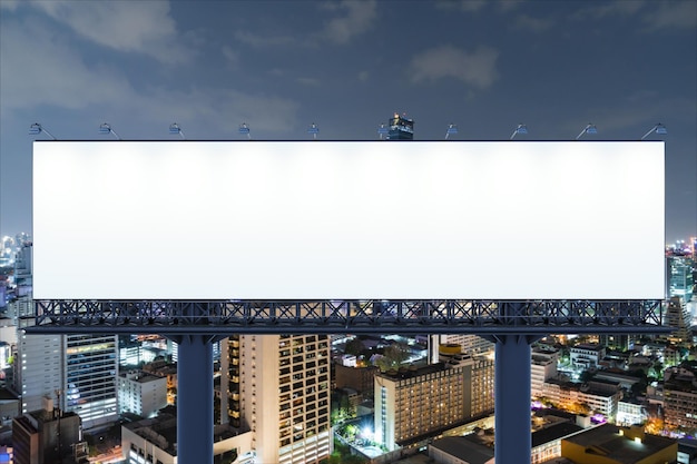 Фото Пустой белый дорожный рекламный щит на фоне городского пейзажа бангкока в ночное время уличный рекламный плакат макет 3d рендеринга вид спереди концепция маркетинговых коммуникаций для продвижения идеи