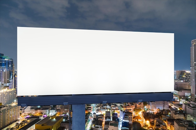 Blank white road billboard with Bangkok cityscape background at night time Street advertising poster mock up 3D rendering Front view The concept of marketing communication to promote idea