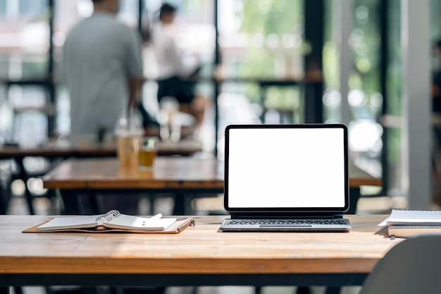 Blank white screen tablet with magic keyboard on wooden table in office room, blurred backgorund of business people.