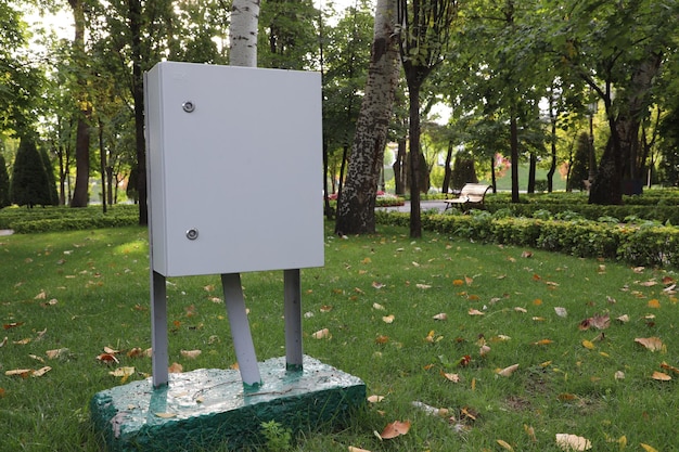 Photo blank white signboard in a public park with trees in the background