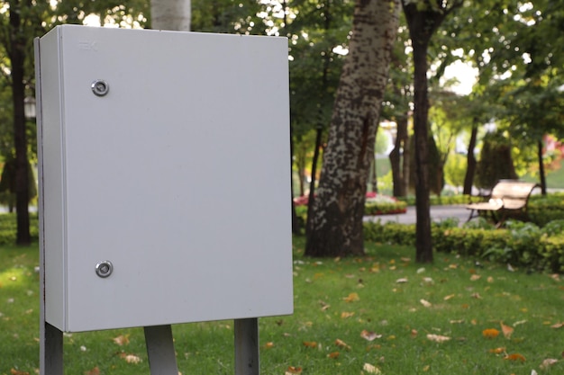 Photo blank white signboard in a public park with trees in the background