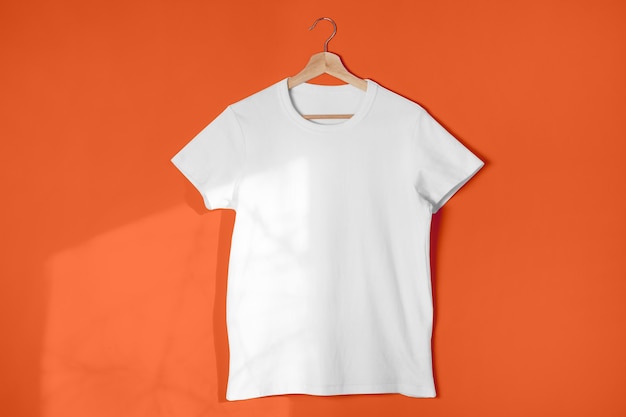 Blank white t-shirt against light orange