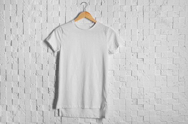 Blank white t-shirt against light textured wall