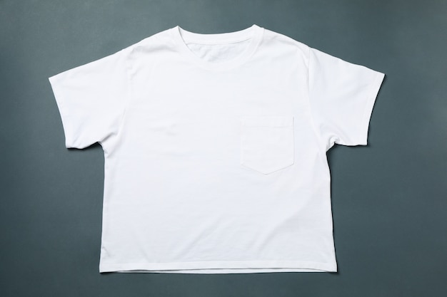 Blank white t-shirt on light black background, space for text