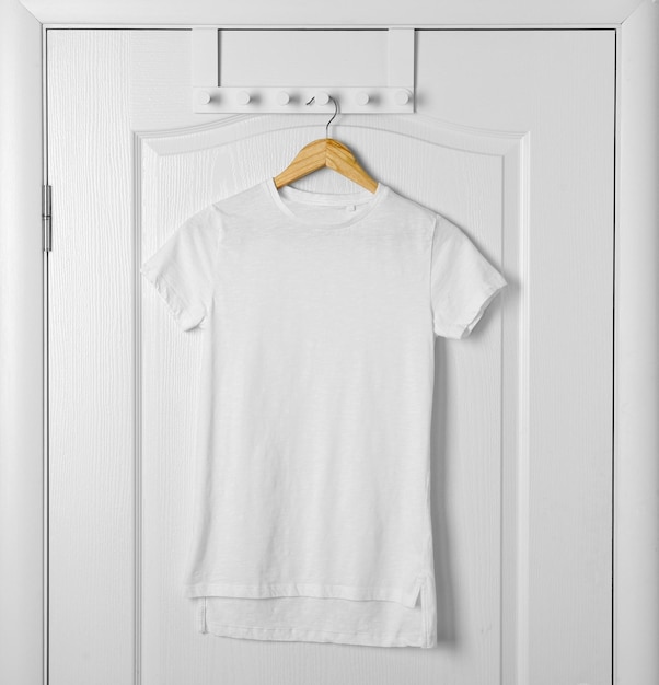 Blank white tshirt hanging on door