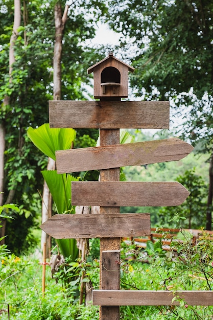 Blank wooden arrows signpost with nest