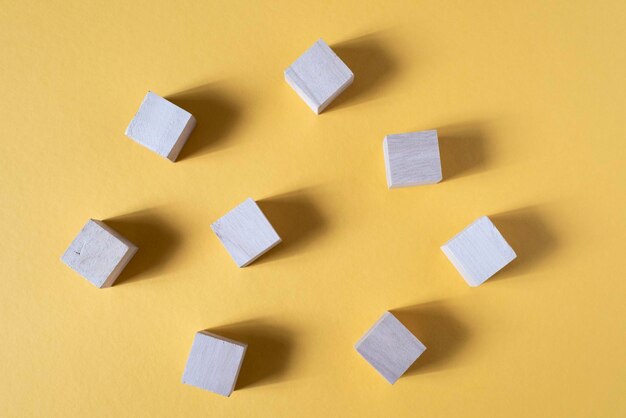 Photo blank wooden cube on a yellow backgorund