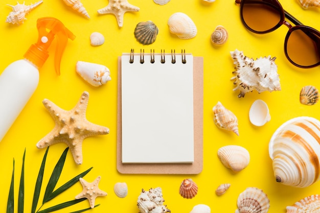 Libro di scrittura in bianco con accessori da spiaggia estivi su sfondo spazio per la copia piatto con spazio per la copia