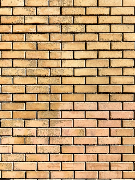 Blank yellow brickwall background texture Empty worn brick wall Ad template copy space Vertical