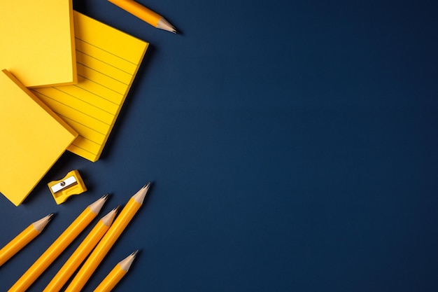 Photo blank yellow sticky note and pencil on navy blue table background