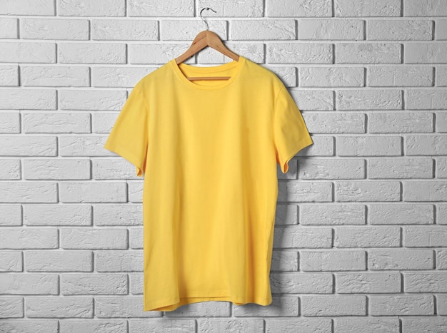 Photo blank yellow tshirt against brick wall