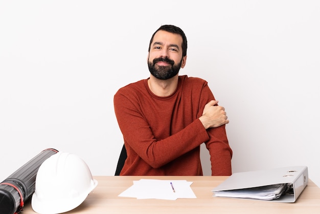 Blanke architect man met baard in een tafel lachen.