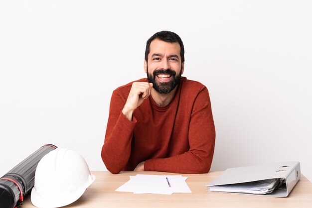 Blanke architect man met baard in een tafel lachen.