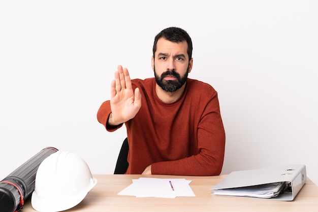 Blanke architect man met baard in een tafel stop gebaar maken.