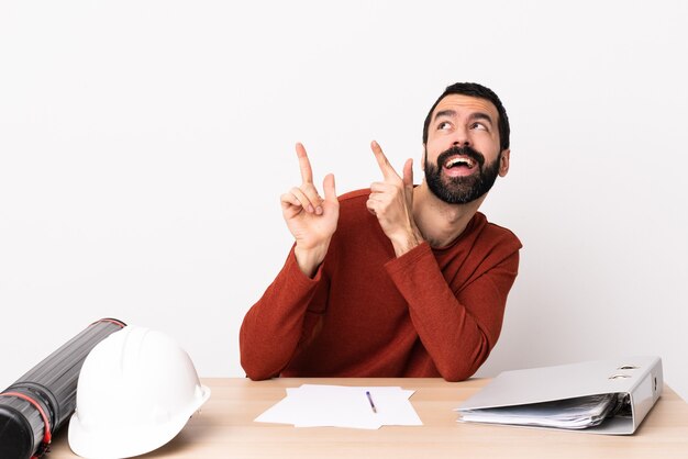 Blanke architect man met baard in een tafel wijzend met de wijsvinger een geweldig idee.