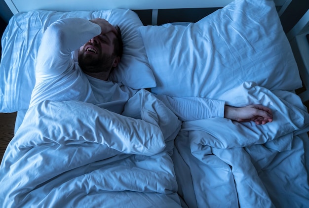 Blanke bebaarde man in pyjama die lijdt aan hoofdpijn legde hij hand op zijn voorhoofd