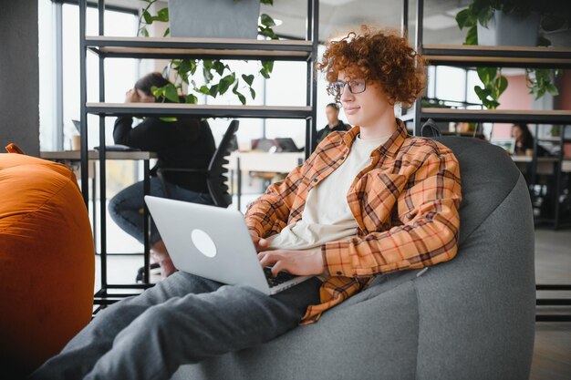 Blanke hipster-man geniet van baan op afstand in coffeeshop mannelijke freelancer in trendy bril zittend in cafetaria met modern laptopapparaat