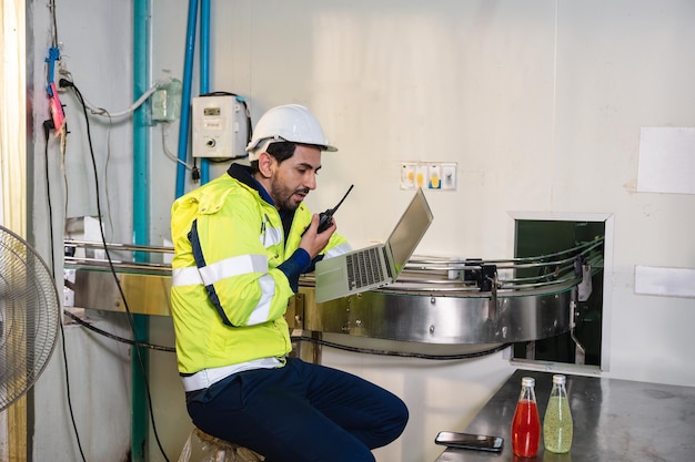 Blanke ingenieur man in veiligheidsuniform die kwaliteit controleert en rapporteert een gebotteld fruit op transportband in verwerkingsbedrijf