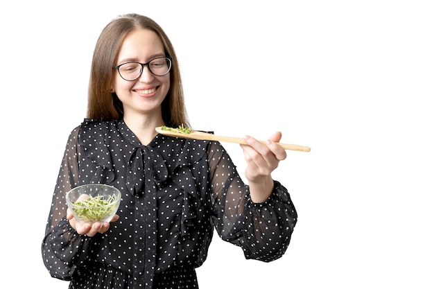 Blanke jonge vrouw met salade geïsoleerd op wit. Microgreens superfood