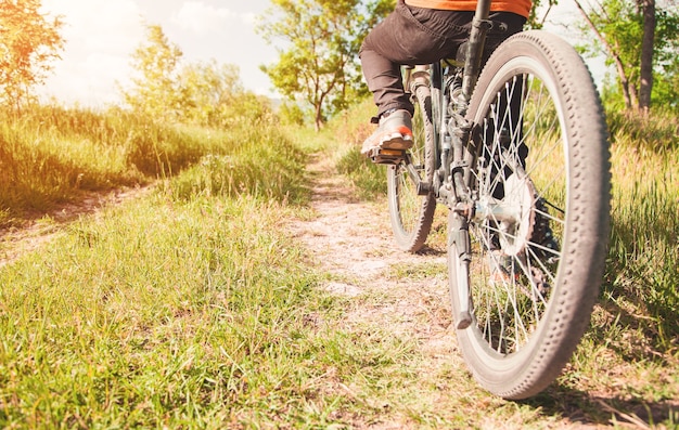 Blanke jongen met een fiets in de buitenlucht.