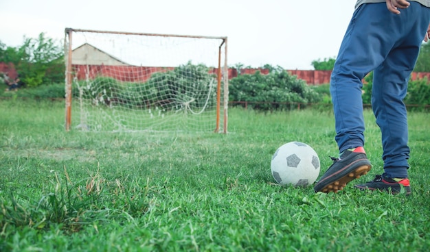 Blanke jongen met een voetbal op een voetbalveld.