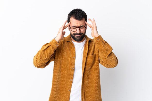 Blanke knappe man met baard draagt een corduroy jasje over wit met hoofdpijn