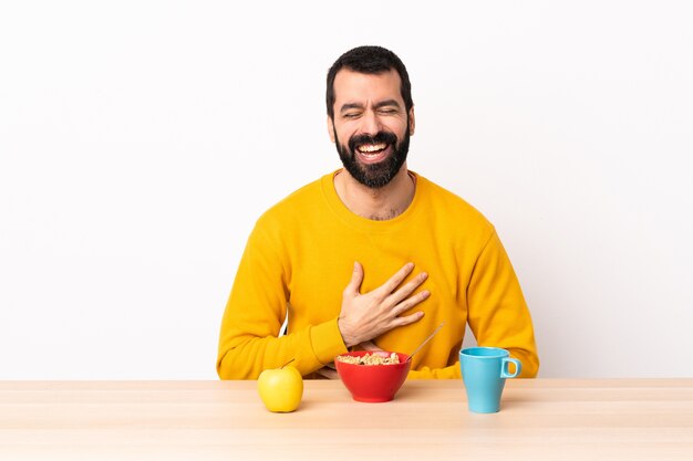 Blanke man aan het ontbijten in een tafel die veel lacht