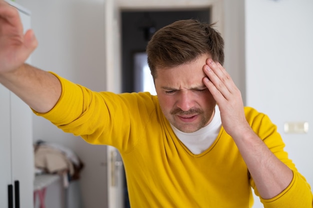 Foto blanke man die laat zien hoeveel pijn zijn hoofd doet als hij pijn ervaart