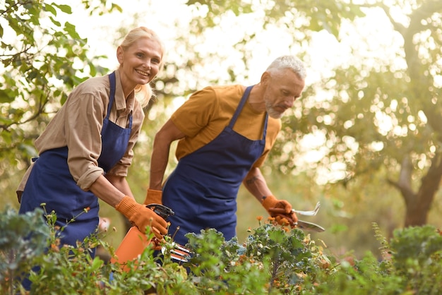 Blanke man en vrouw van middelbare leeftijd die in de tuin werken