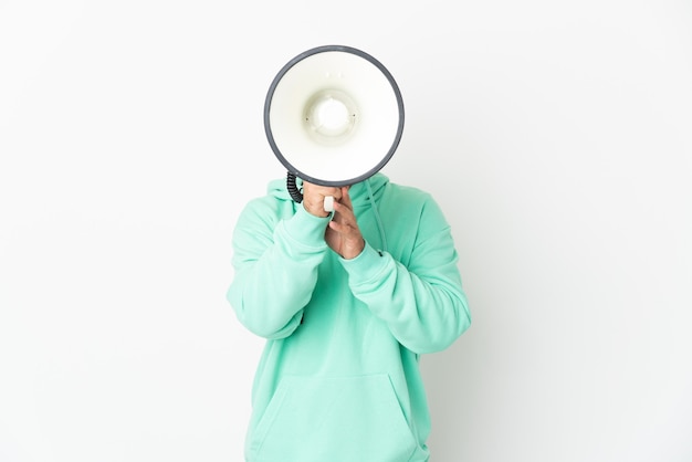 Foto blanke man geïsoleerd op een witte muur schreeuwen door een megafoon om iets aan te kondigen