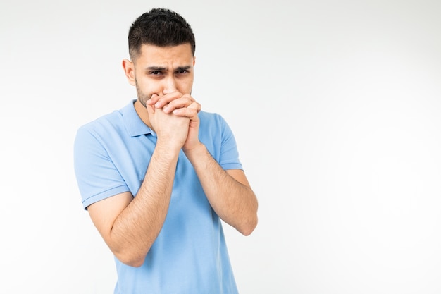 Blanke man in een blauw T-shirt vraagt oprecht om iets op een witte geïsoleerde achtergrond.