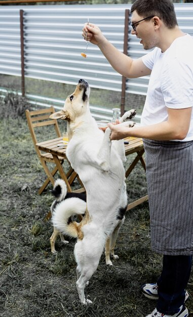 Blanke man kust een hond, loopt buiten in de achtertuin