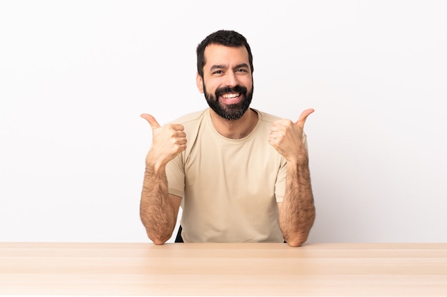 Blanke man met baard in een tabel met een duim omhoog gebaar