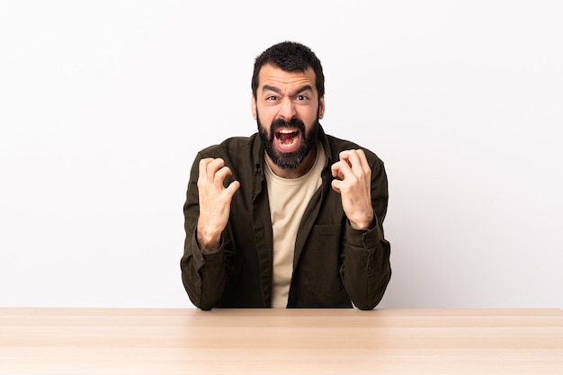 Blanke man met baard in een tafel gefrustreerd door een slechte situatie