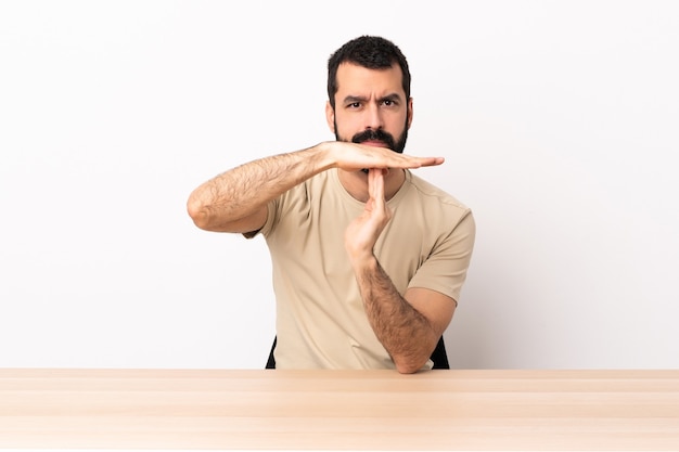 Blanke man met baard in een tafel time-out gebaar maken.