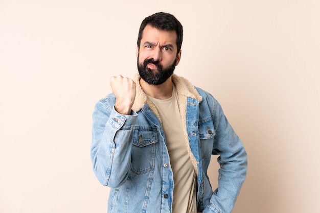 Blanke man met baard over geïsoleerde achtergrond met ongelukkige uitdrukking